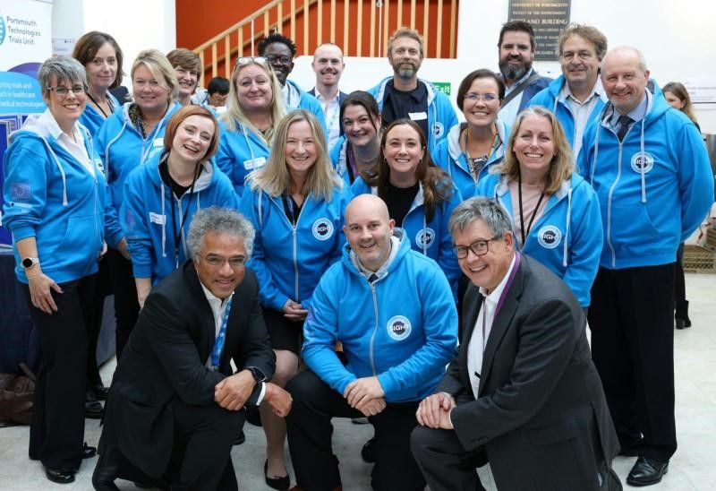 A group of people stood smiling in matching blue hoodies 